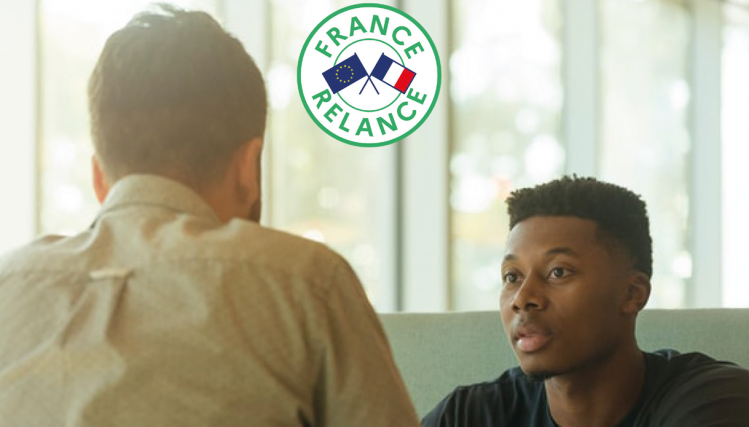 Photo d'un recruteur de dos qui parle à une jeune homme, en entetien. La photo porte le logo France Relance.