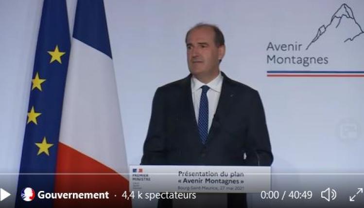 Photo du Premier minstre, au pupitre, pour son discours avec les drapeaux France et UE à côté 