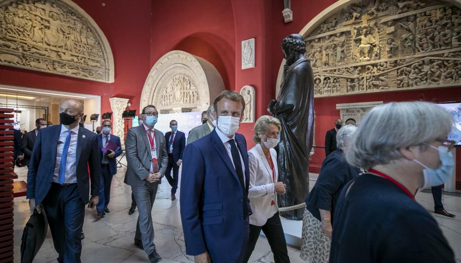 Le président de la République, Emmanuel Macron, traverse la galerie de la Cité du patrimoine en compagnie de Caroline Cayeux