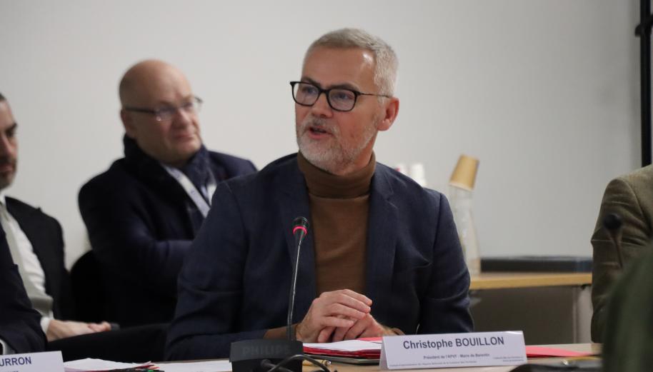 Assis à une table de réunion, Christophe Bouillon cheveux gris courts, lunettes noires. Il est en train de parler et se tourne vers ses interlocuteurs de droite.
